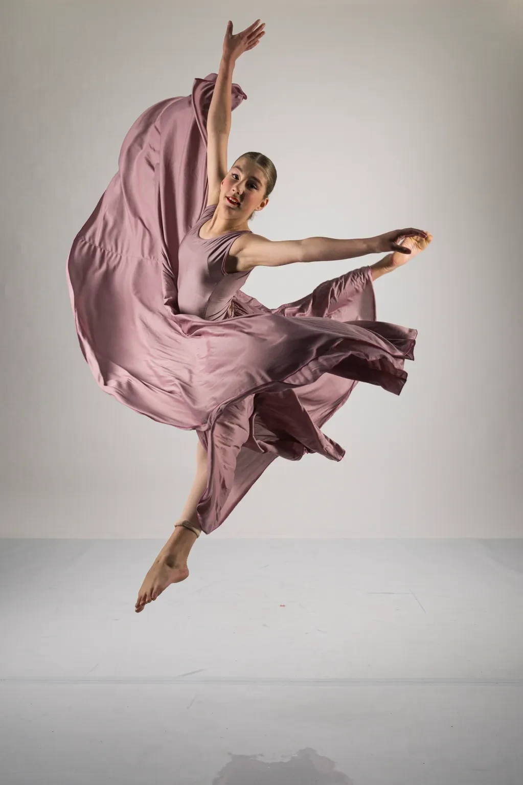 Ballet dancer leaping in pink fabric