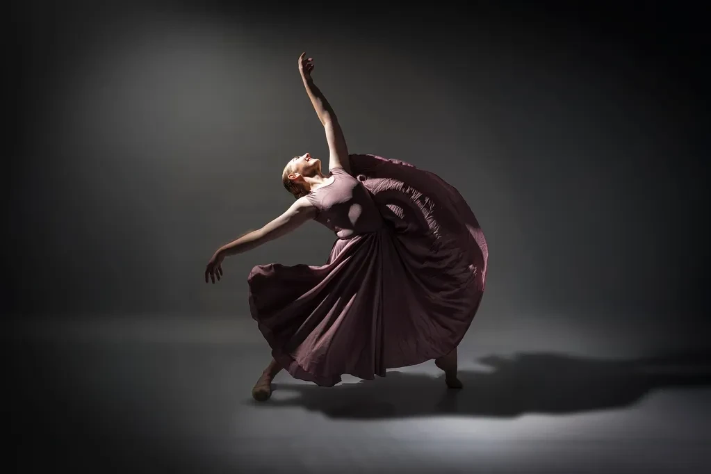 Ballet dancer in burgundy dress leaping